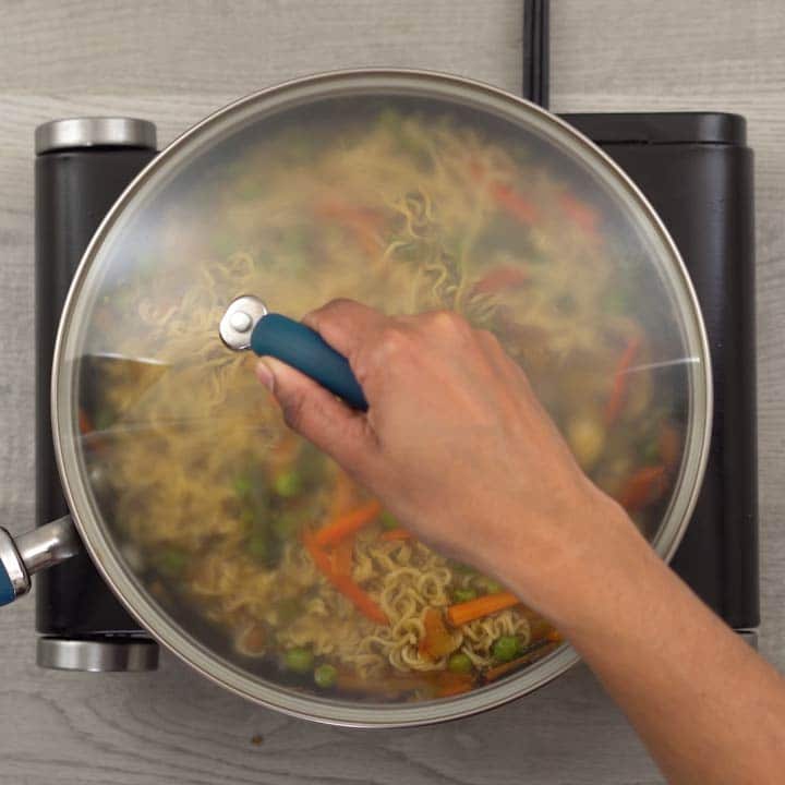 Noodles cooking in pan with the lid closed