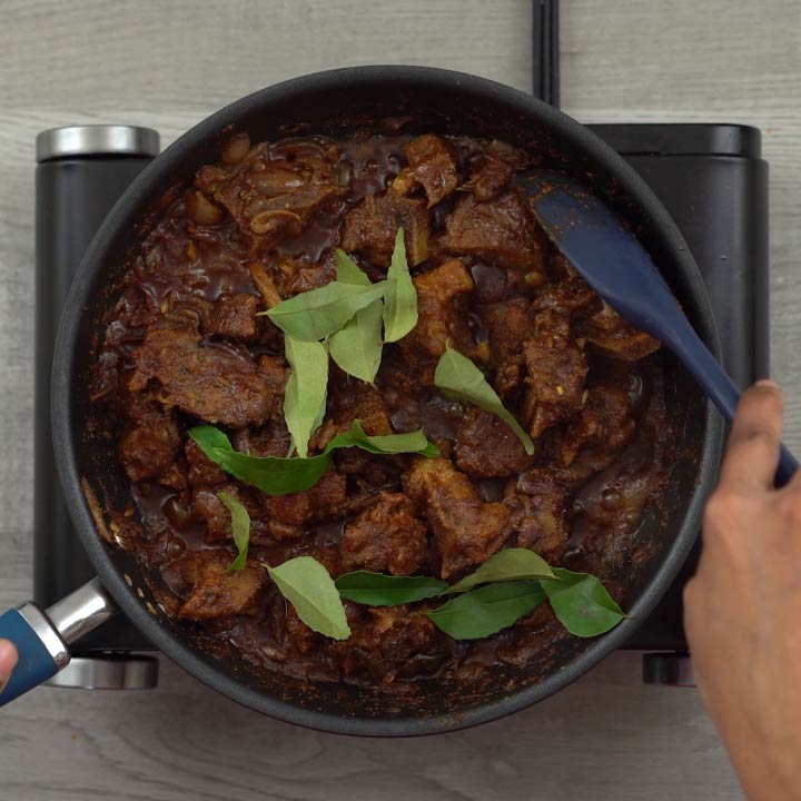 Adding curry leaves to mutton chukka