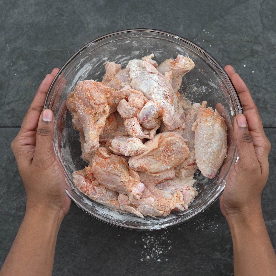 flour coated chicken wings in a bowl