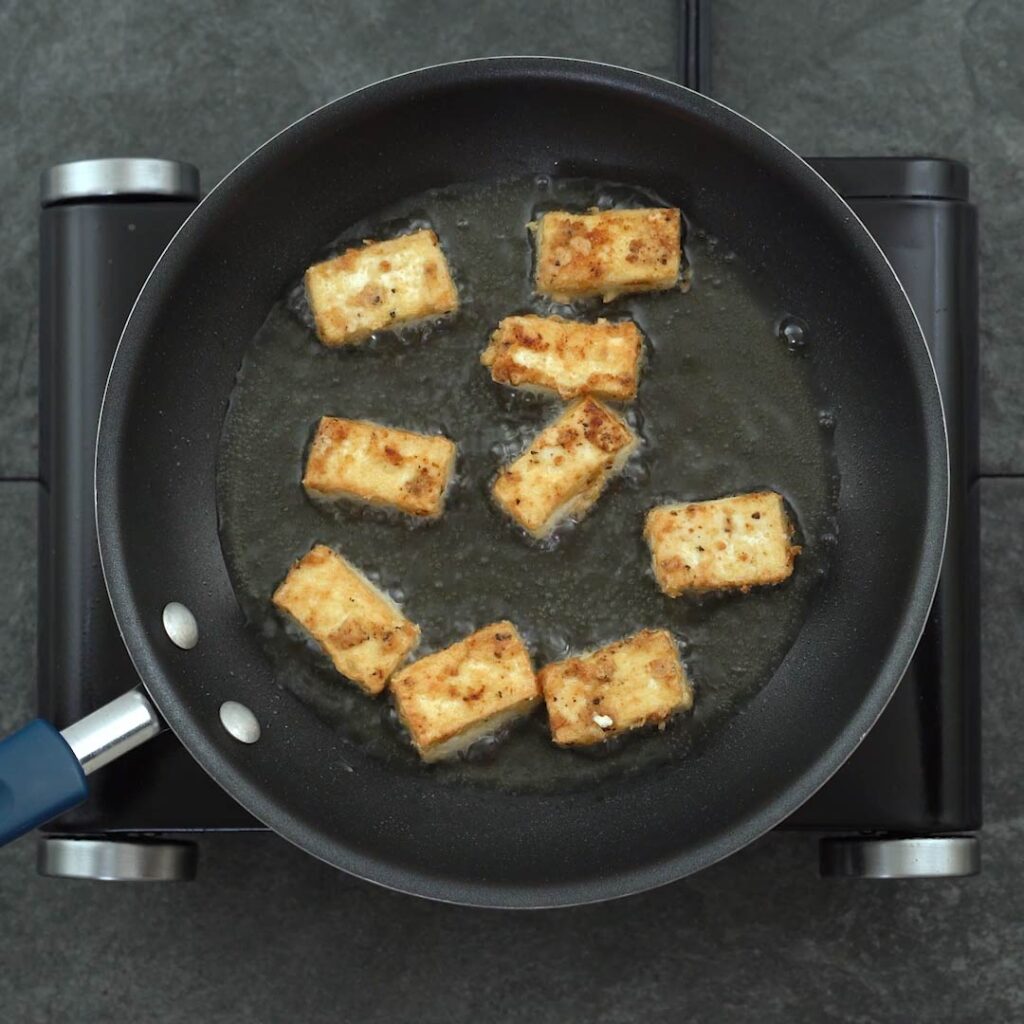 tofu is frying in a pan