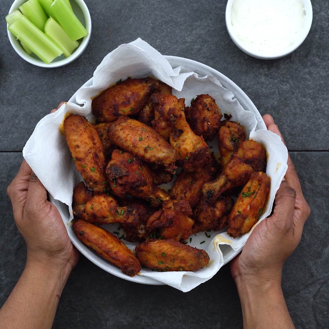 Serving crispy Air Fryer Chicken Wings with celery sticks and ranch