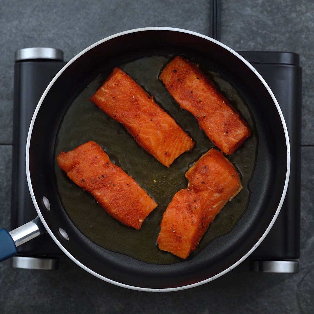 Seasoned Salmon frying in a pan