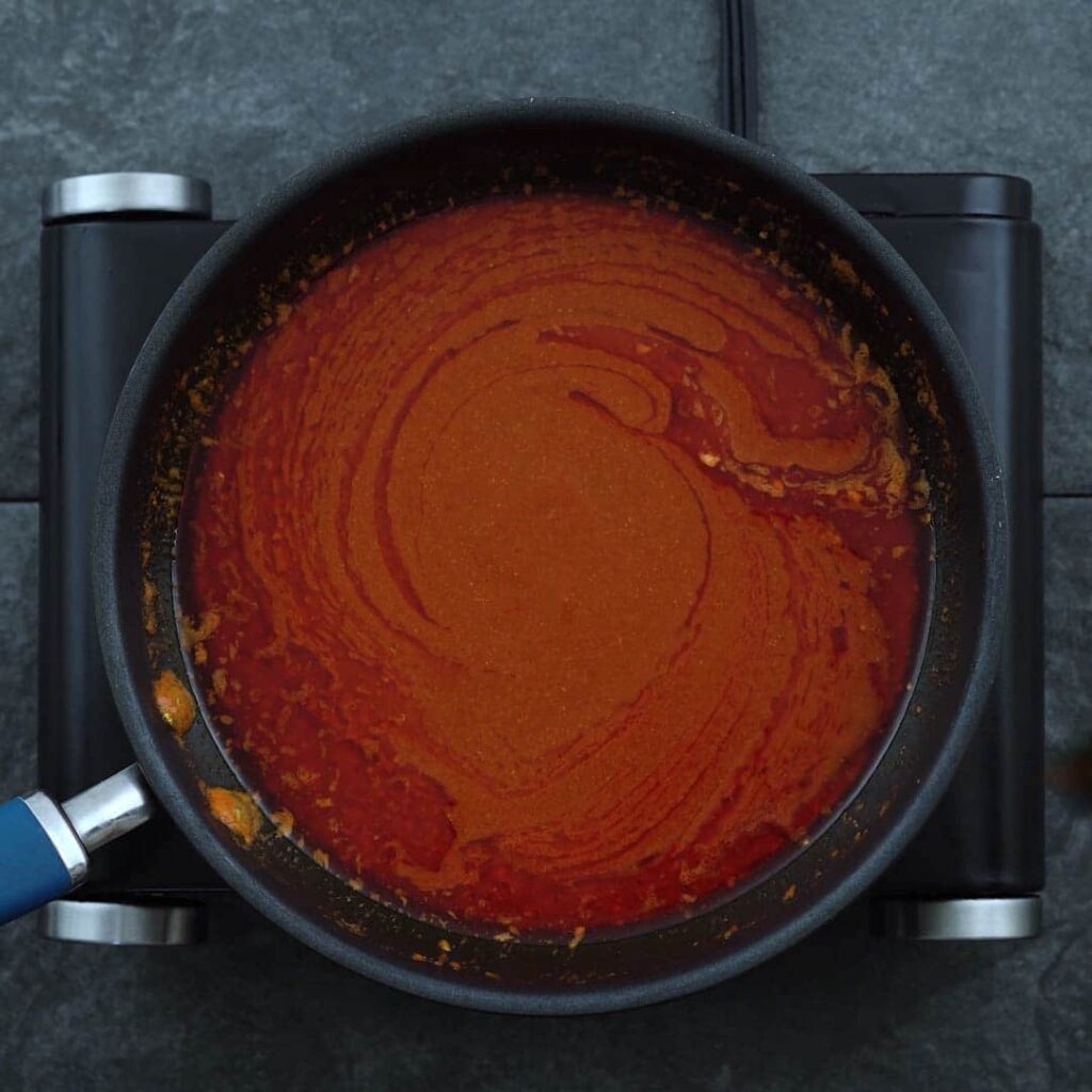 Buffalo Sauce is simmering in a pan